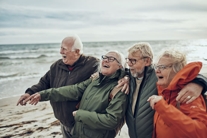 Eine Reisegruppe lacht gemeinsam am Strand